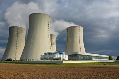 Una central nuclear con tres torres de refrigeración hiperbólicas.